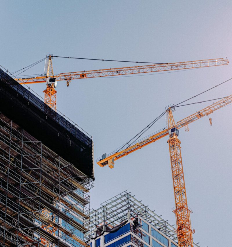 low-angle-of-two-cranes-in-a-construction-site-und-2026-01-07-07-37-14-utc