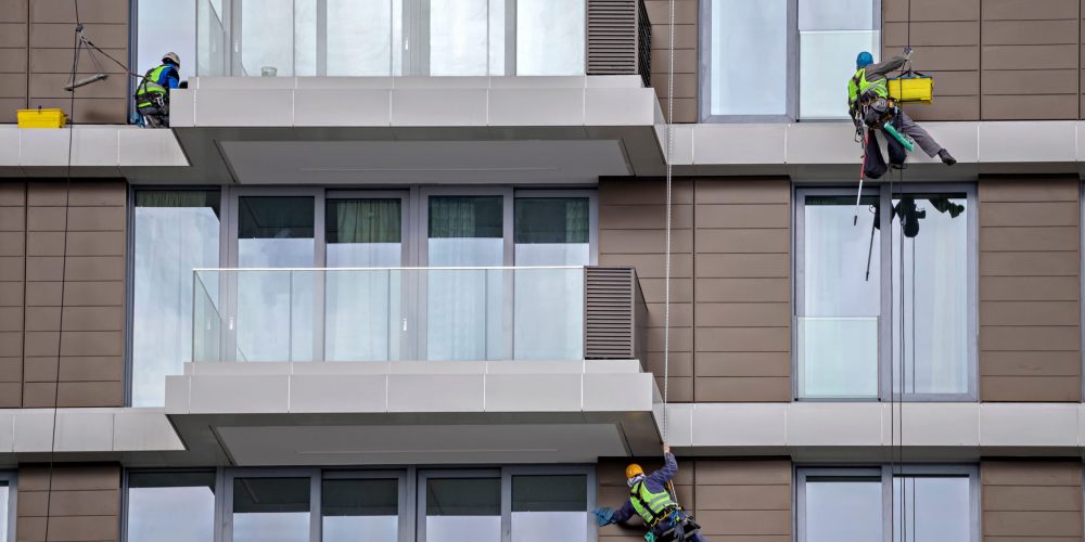 worker-using-rope-to-clean-a-high-apartment-buildi-2026-01-11-09-31-56-utc